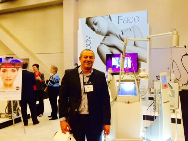 Francisco Canales, MD standing next to UltraShape machine in Exhibit Hall